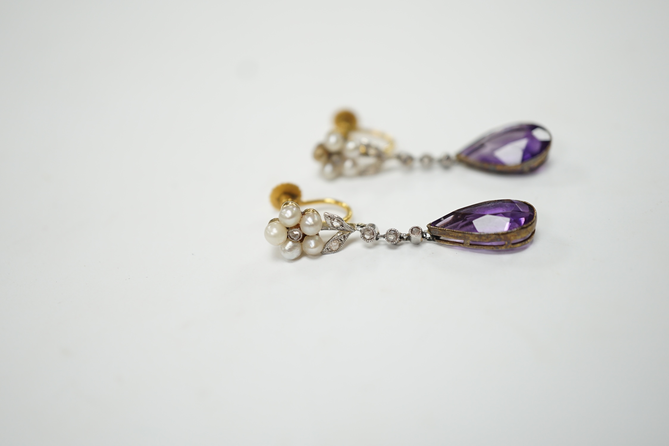 A pair of early to mid 20th century 9ct, amethyst, diamond and seed pearl set drop ear clips, 34mm, gross weight 4.7 grams. Fair to poor condition.